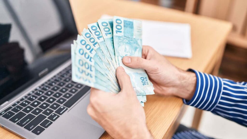 Homem segurando dinheiro - Créditos: depositphotos.com / Krakenimages.com